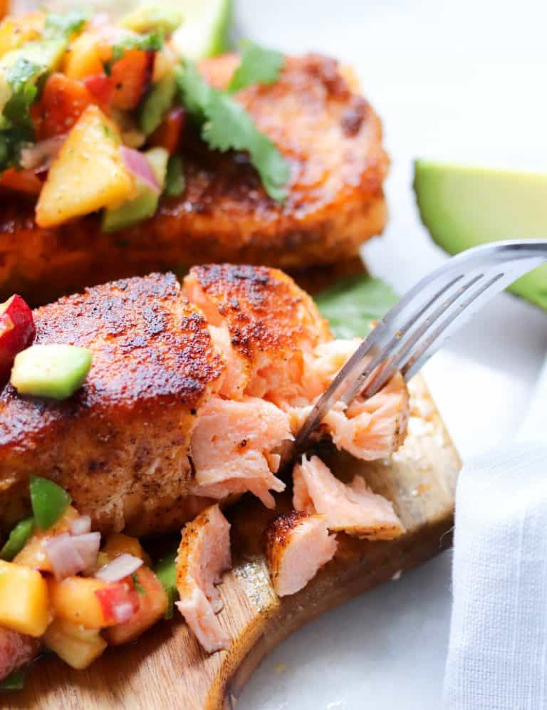 blackened salmon with peach salsa on wooden cutting board