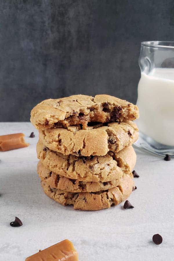 stack of peanut butter chocolate chip cookies next to a glass of milk