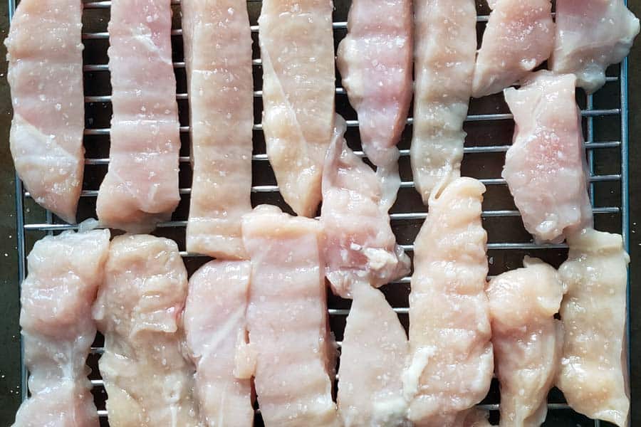 Chicken strips dry brining on cooling rack