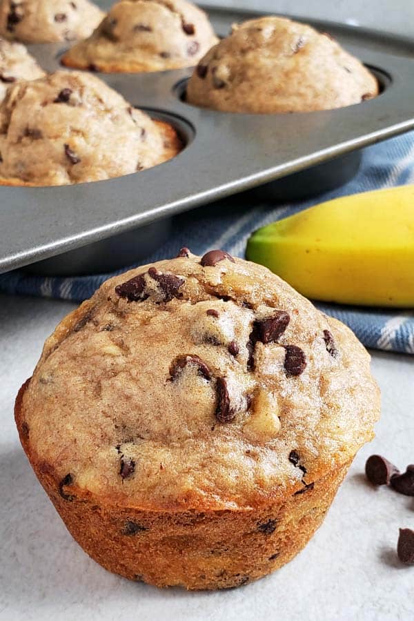 close up of sourdough chocolate chip banana muffin on a white background
